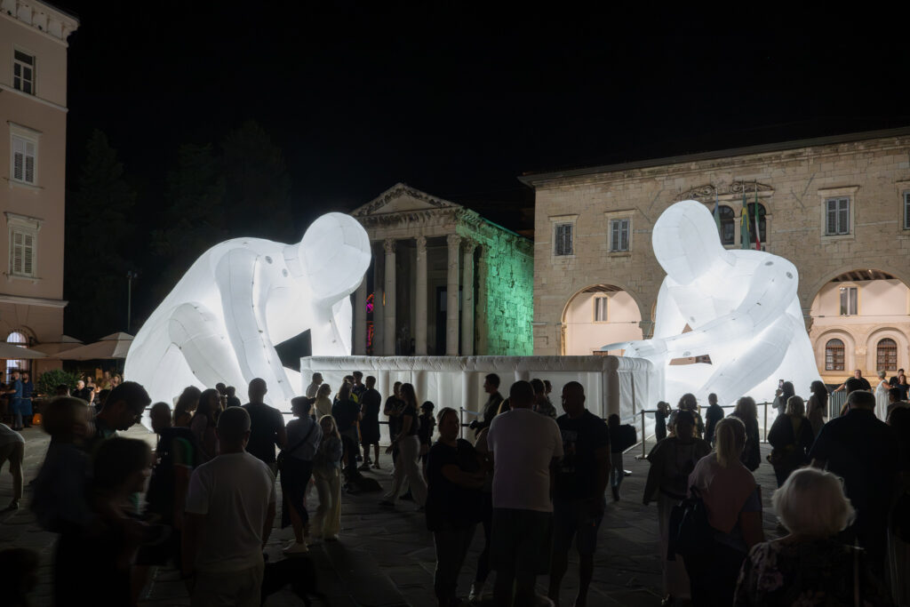 Dva čovjeka u svjetlosnoj instalaciji na Forum lokaciji tijekom Visualia festivala u Puli 2025.